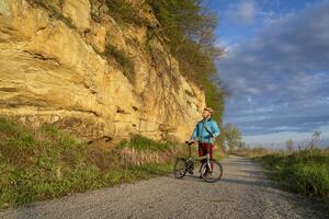 Sénior Masculin cycliste équitation une pliant bicyclette sur bateau à vapeur trace, bicyclette Piste converti de un abandonné chemin de fer, près Pérou, Nebraska, printemps Matin paysage photo