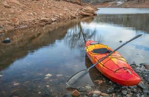 coloré rivière kayak sur une rocheux rive de Montagne Lac - des loisirs concept photo