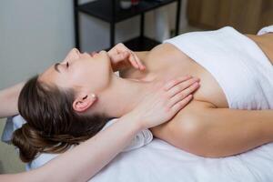 magnifique Jeune femme avoir faciale massage dans spa salon. beauté traitement concept. photo