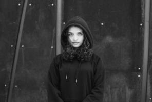 blanc brunette adolescent fille avec frisé cheveux pose sur le rue dans le ville. photo