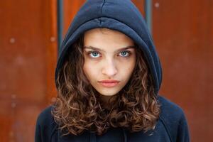 blanc brunette adolescent fille avec frisé cheveux pose sur le rue dans le ville. photo