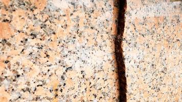 véritable motif de granit brun naturel, tranche minérale polie. texture béton endommagée en marbre fissuré sans couture. arrière-plan architectural. taches brunes sur fond de pierre. marbrure photo