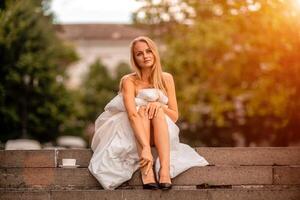 femme ville couverture. Matin dans le gros ville. une blond femme dans une blanc couverture est profiter dans le ville centre. photographié pour social médias photo