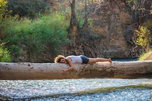 content Jeune femme posant sur une Journal plus de une rivière photo