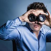 photographe regardant à travers des lentilles en studio photo