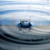 la goutte d'eau transparente et ronde, tombe vers le bas photo