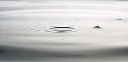 la goutte d'eau transparente et ronde, tombe vers le bas photo