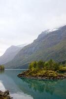 magnifique norvégien paysage dans l'automne près prêter et stryn dans Norvège,lovatnet dans octobre, lac avec turquoise l'eau et faible des nuages au dessus photo