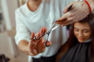 coiffeur en portant les ciseaux dans le sien mains et Coupe client cheveux photo