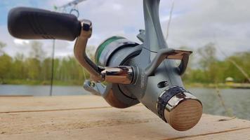 canne à pêche à la carpe isolée sur le lac et pont en bois. moulinet de filature d'alimentation de carpe se bouchent. pêche à la carpe sur le lac. matériel de pêcheur. ukraine, kiev - 09 juin 2021. photo