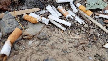 beaucoup de mégots de cigarettes. la cause du cancer du poumon. de nombreux mégots de cigarettes usagés comme poubelle photo