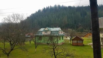 vue paysage d'un village de montagne dans les carpates à l'automne depuis la fenêtre du train. une vue d'un vieux train d'un village de montagne photo