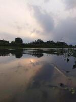 le Soleil est réglage plus de une rivière dans le distance photo