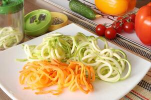 tranché des légumes et récipient de légume trancheuse sur cuisine tableau. photo