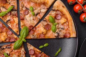 délicieux Pizza avec saucisse, fromage, tomates, sel, épices et herbes photo