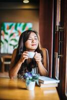 portrait, femme asiatique, sourire, se détendre, dans, café-restaurant, café photo