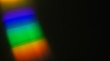 Coloré bleu et jaune et vert superposition de lumière réfraction texture diagonale holographique naturel sur noir.