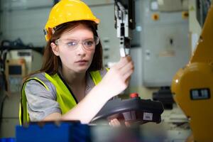 femelle technicien qui maintient une petit robot bras le opération de une petit robot bras utilisé dans industrie est étant réparé. photo