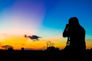 silhouette photographe avec le coucher du soleil photo