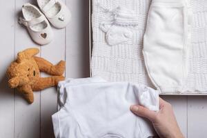 femelle mains mettre enfants vêtements, des chaussures et jouets dans une boîte. seconde main, Vêtements recyclage concept photo