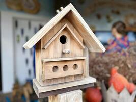 une en bois oiseau mangeoire près maison. sélectif concentrer sur le partie de le mangeoire photo