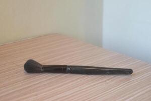 une noir brosse est sur une en bois table photo