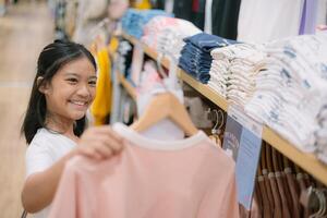 une Jeune fille est achats pour vêtements dans une boutique photo