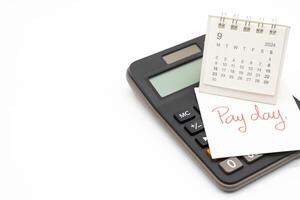 main l'écriture texte Payer journée sur septembre calendrier avec calculatrice dans isolé Contexte. rappel concept de paiement. photo