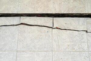 maison brisée. fissure du béton. intérieur du bâtiment endommagé par l'eau. grand mur de béton blanc fissuré photo