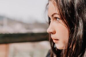 content Jeune souriant femme avec taches de rousseur en plein air portrait. doux ensoleillé couleurs. Extérieur fermer portrait de une Jeune brunette femme et à la recherche à le caméra, posant contre l'automne la nature Contexte photo