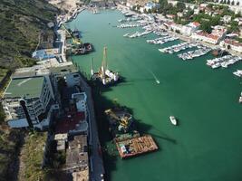 aérien panoramique vue de balaklava paysage avec bateaux et mer dans Marina baie. Crimée sévastopol touristique attraction. drone Haut vue coup de Port pour luxe voiliers, bateaux et voiliers. photo