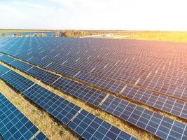 aérien Haut vue de une solaire panneaux Puissance plante. photovoltaïque solaire panneaux à lever du soleil et le coucher du soleil dans campagne de au-dessus de. moderne technologie, climat se soucier, Terre économie, renouvelable énergie concept. photo