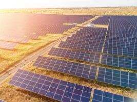 aérien Haut vue de une solaire panneaux Puissance plante. photovoltaïque solaire panneaux à lever du soleil et le coucher du soleil dans campagne de au-dessus de. moderne technologie, climat se soucier, Terre économie, renouvelable énergie concept. photo