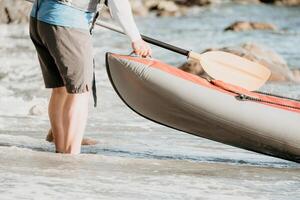 content couple kayaks dans un gonflable kayak sur le mer à le coucher du soleil. couple faire du canoë dans le mer près le île avec montagnes. gens kayak dans la vie vestes naviguer. retour vue photo