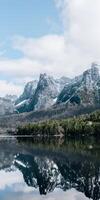 enneigé pics réfléchi dans serein Montagne Lac photo