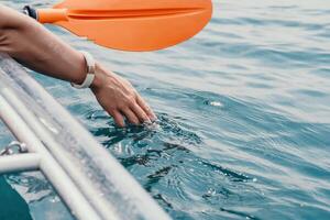 femme dans kayak retour voir. content Jeune femme avec longue cheveux flottant dans transparent kayak sur le cristal clair mer. été vacances vacances et de bonne humeur femelle gens relaxant ayant amusement sur le bateau photo