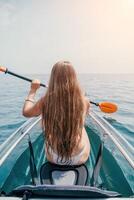 femme dans kayak retour voir. content Jeune femme avec longue cheveux flottant dans transparent kayak sur le cristal clair mer. été vacances vacances et de bonne humeur femelle gens relaxant ayant amusement sur le bateau photo