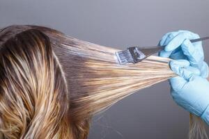 professionnel coiffeur teinture cheveux de sa client dans salon. sélectif se concentrer. photo