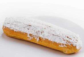 éclair dans blanc glaçage et noix de coco flocons photo