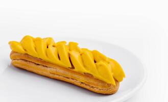 éclair avec mangue crème sur blanc assiette photo