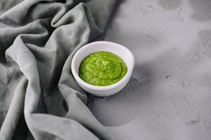 Frais fait maison vert Pesto sauce dans blanc bol photo