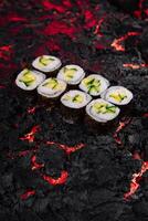Avocat Sushi Rouleaux sur ardent lave texture Contexte photo