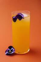 tropical Orange cocktail avec comestible fleur garnir photo