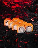 Saumon Sushi Rouleaux sur charbon Contexte photo