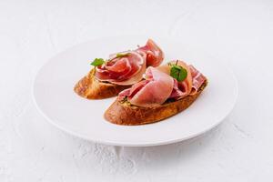 élégant prosciutto Bruschetta sur blanc assiette photo