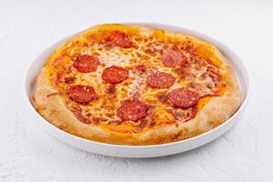 fraîchement cuit pepperoni Pizza sur blanc assiette photo
