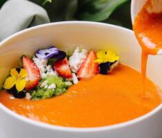 gourmet citrouille soupe avec comestible fleurs photo