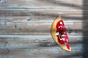 tranche de pizza avec des ingrédients sur fond en bois. espace de copie ajouté pour le texte. photo