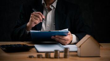 homme d'affaire en cours d'analyse les documents avec calculatrice. affaires banque la finance budget Planification maison Paiement argent hypothèque propriété, refinancer ou impôt réel biens concept photo