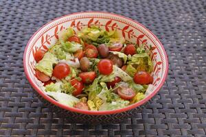 vert salade avec Cerise tomates, Olives, oignon, Frais herbes, citron jus et olive pétrole photo